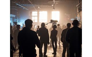 Behind-the-scenes shot of a movie set with crew and equipment.